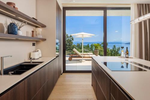 a kitchen with a view of the ocean at Opatija Luxury Villa Ella in Mošćenička Draga