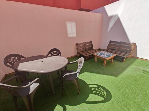 a room with a table and chairs and benches at Esencia de Sal in San Antonio