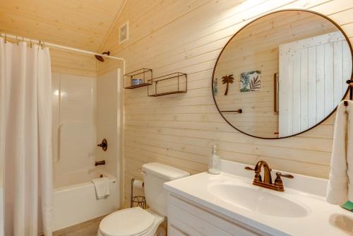 a bathroom with a toilet and a sink and a mirror at 2 Mi to Carrabelle Beach Home with Yard and Porch in Carrabelle