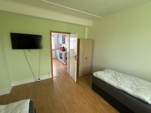 a bedroom with two beds and a flat screen tv at Wohnung in Troisdorf T05 in Troisdorf