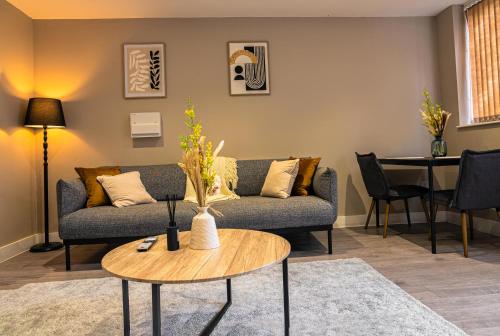 a living room with a couch and a table at Stylish Flat in Wolverhampton - Short and long Stay with Free Parking in Wolverhampton