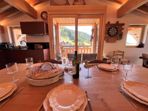 - une table en bois avec une bouteille de vin et des verres dans l'établissement Appartement chaleureux, 3 chambres, terrasses, parking - FR-1-598-108, aux Gets