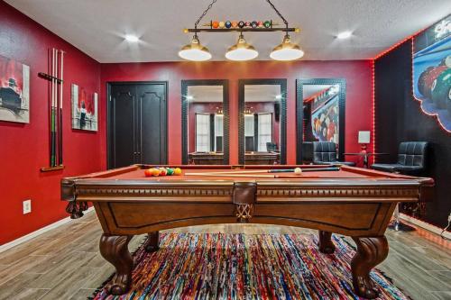 a pool table in a room with red walls at Spacious Ou Hideaway Hot Tub Pool Table in Norman