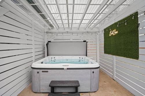 a jacuzzi tub in a white room with a sign at Spacious Ou Hideaway Hot Tub Pool Table in Norman
