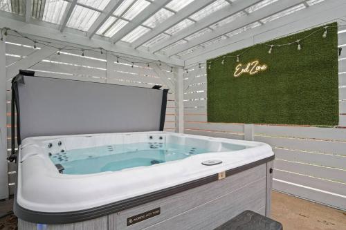 a jacuzzi tub in a room with a sign at Spacious Ou Hideaway Hot Tub Pool Table in Norman