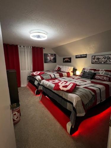 a bedroom with two twin beds with red lighting at Spacious Ou Hideaway Hot Tub Pool Table in Norman