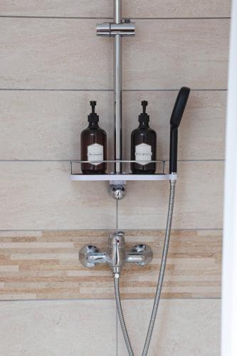 a shower with two soap bottles on a shelf at CDG • Mer de Sable • P.Asterix • Disney • Parking in Saint-Mard