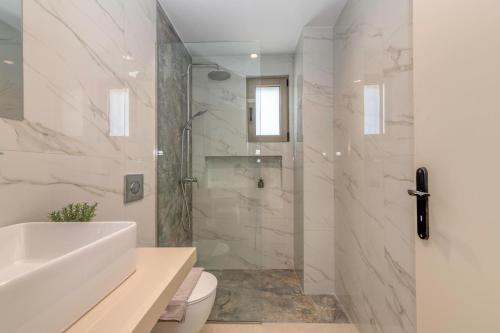 a bathroom with a shower and a toilet and a sink at Elafonisi Pearl in Elafonisi
