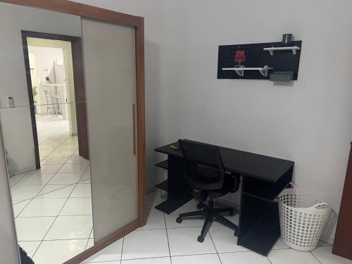an office with a desk and a mirror at Suítes & Quartos Ponte do Imaruim in Palhoça