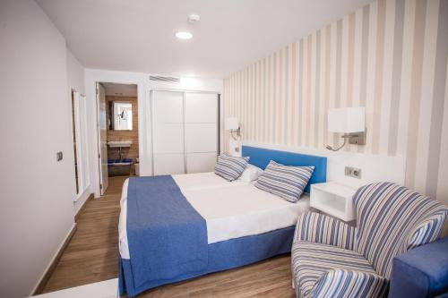 a hotel room with a bed and a chair at IG Nachosol Atlantic & Yaizasol by Servatur - Adults Only in Puerto Rico de Gran Canaria