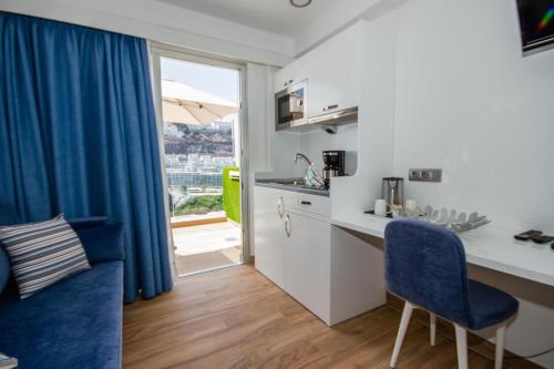 a kitchen with a desk and a blue chair at IG Nachosol Atlantic & Yaizasol by Servatur - Adults Only in Puerto Rico de Gran Canaria
