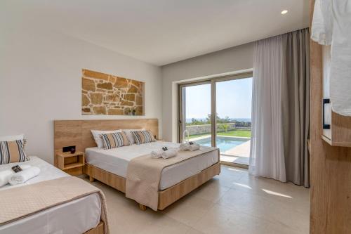 a bedroom with two beds and a large window at Elafonisi Pearl in Elafonisi