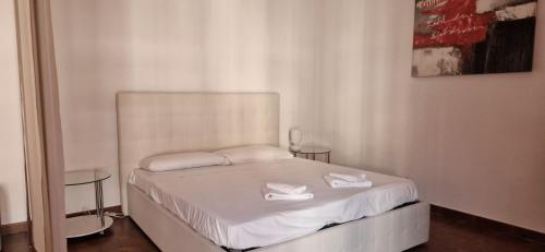 a bedroom with a bed with white sheets and two tables at ROSSO MAGENTA - Luminoso loft in centro e a due passi dalla stazione in Turin