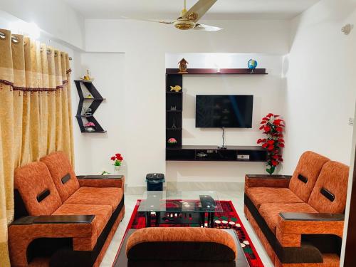 a living room with two couches and a tv at Sylhet Zindabazar area in Sylhet