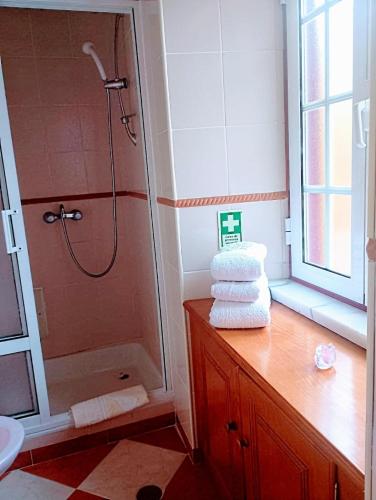 un bagno con doccia e una pila di asciugamani di Casa Vidas de Loriga a Loriga