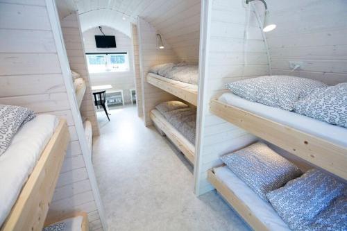 a room with four bunk beds and a table at SportsPark Blaavandshuk Resort in Oksbøl