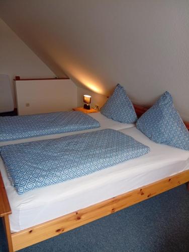 a large bed with blue pillows in a room at Zur Schleibrücke in Boren