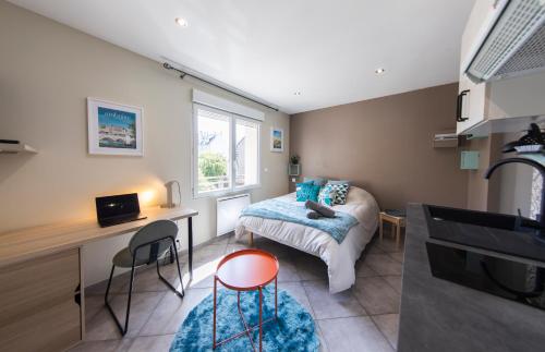 a bedroom with a bed and a desk and a kitchen at Studio Cosy La Fuye, proche gare, VELORA in Tours