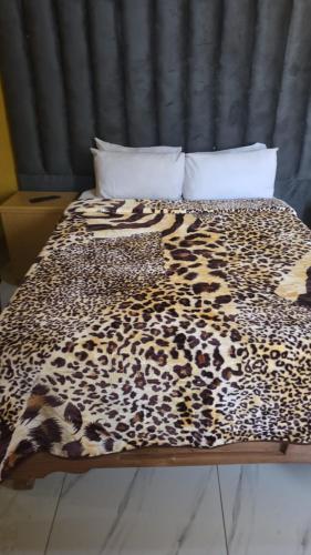 un lit avec une couverture à imprimé léopard dessus dans l'établissement Neethling 6 Guest House, à Johannesbourg