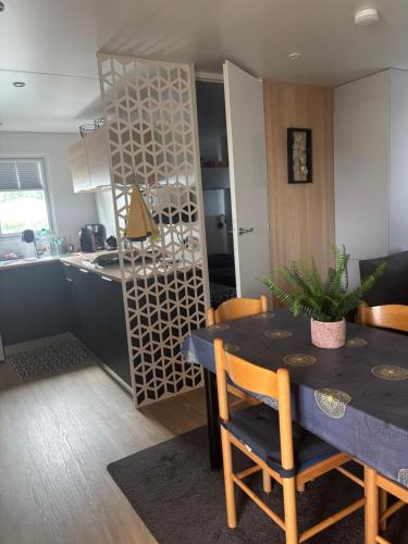 a kitchen and a dining room with a table and chairs at Mobilhome Camping piscine Hyères Plage in Hyères