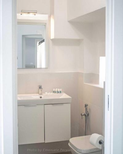 a bathroom with a sink and a mirror and a toilet at Il corso in Norcia