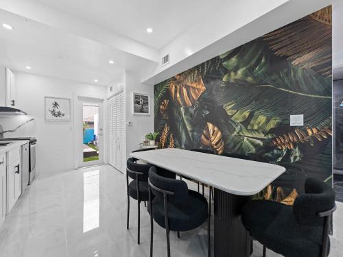a kitchen with a table and some black chairs at Villa mi Amor Walkable Pool & Games in Miami