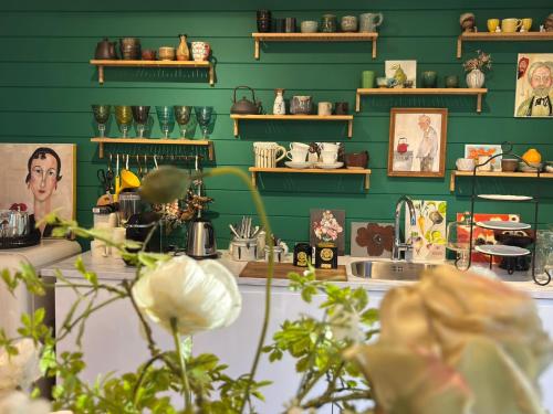 a room with green walls and a counter with flowers at A Calm & Quiet Stay in Wuustwezel