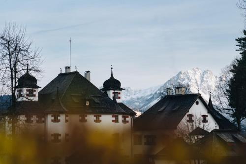 an old building with a mountain in the background at Schlosshotel Kitzbühel in Kitzbühel