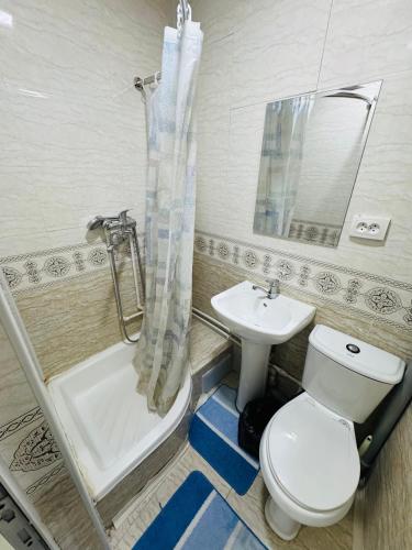 a bathroom with a toilet and a sink and a shower at Uncle Kolya Hotel str M Azam 39 in Bukhara