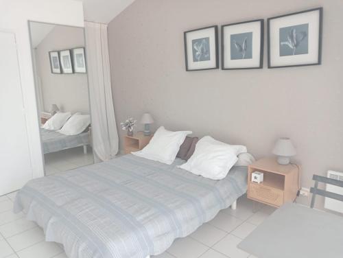 a white bedroom with a bed and a mirror at Chambre Indépendante sur terrain avec piscine in Ollières