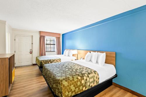a hotel room with two beds and a blue wall at Econo Lodge Augusta North - Washington Road in Augusta