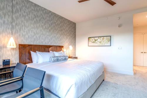 a bedroom with a large bed and two chairs at Honua Kai Luana Condos by KBM Resorts in Kaanapali