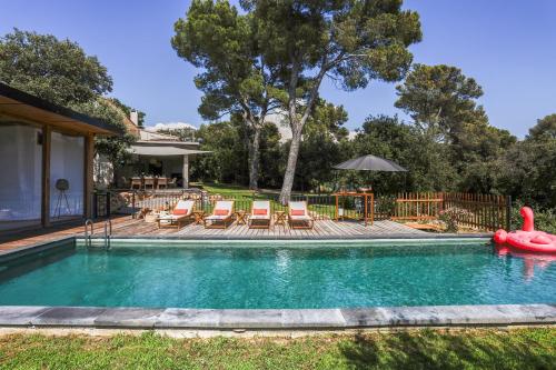 une piscine avec un radeau gonflable rouge dans une cour dans l'établissement Big Modern Villa Ste Victoire 10min CityCenter Aix, à Saint-Marc-Jaumegarde