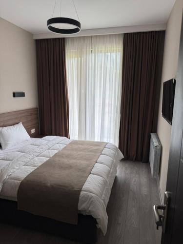 a bedroom with a large bed in front of a window at Bakuriani Crystal Loft Apt in Bakuriani