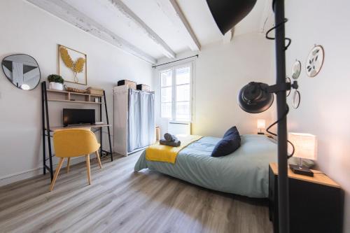 a bedroom with a bed and a desk and a chair at Studio Cosy Les 3 écritoires, hyper centre, wifi, VELORA in Tours