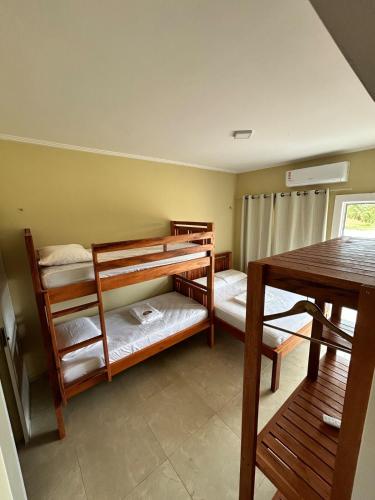 a room with two bunk beds and a table at Triplex Dunas - Flecheiras in Trairi