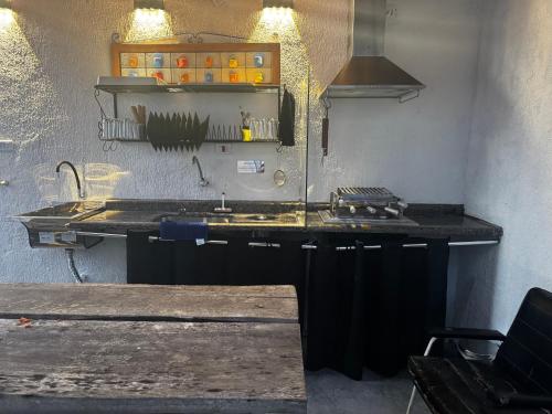 a kitchen with a sink and a counter top at No Centro com Piscina Aquecida solar in Peruíbe
