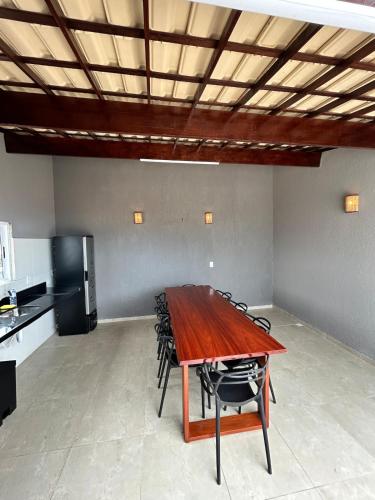 a dining room with a wooden table and chairs at Triplex Dunas - Flecheiras in Trairi