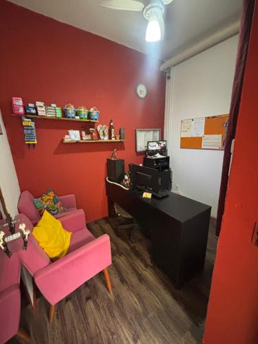a room with a desk and a chair and a computer at Pousada São Marcos in Santos
