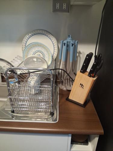 a dish rack with plates and utensils on a counter at Departamento por día 2 Dormitorios Wi Fi in Chillán