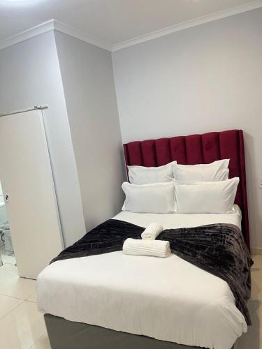 a bed with a red headboard in a room at The Perfect Place in Parow