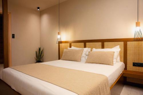 a bedroom with a large white bed with two pillows at Kasta Beach Hotel in Ofrínion