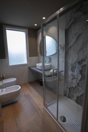 a bathroom with a glass shower and a sink at Tosa Welcome in Imola