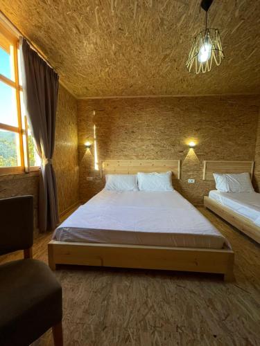 a bedroom with a large bed and a chandelier at Xhagolands in Përmet