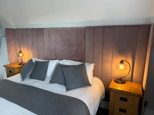 a bedroom with a large bed with two lamps on tables at Oaklands Hotel in Norwich