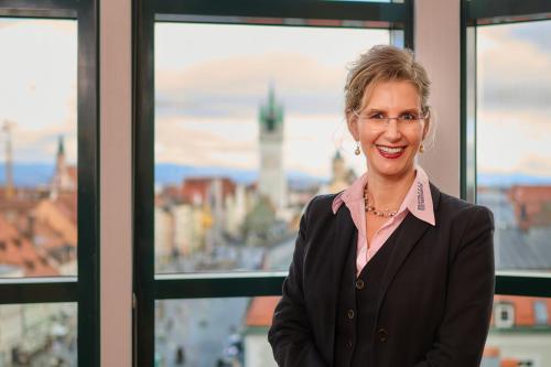 a woman in a suit standing in front of a window at Hotel Theresientor in Straubing