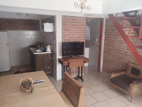 a living room with a table and a kitchen at Cabañas Guer Aike in Villa Carlos Paz