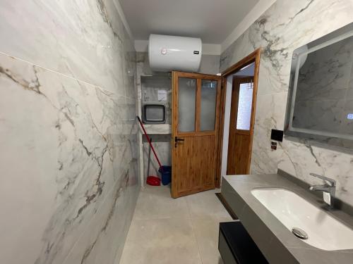 a bathroom with a sink and a mirror at Rajan Rooms in Vlorë
