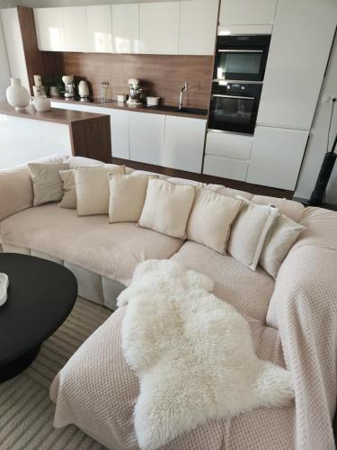 a living room with a couch with a white blanket at Appartement neuf in Ajaccio