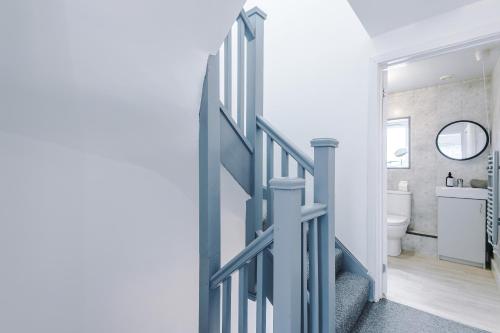 a hallway with a blue door leading to a bathroom at The Hansas Residences - Two Elegant & Spacious Townhouses - Perfect for Business or Work Stays by Parydise Properties in Harlescott